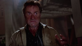 Movie still from “Gremlins 2: The New Batch” (1990), directed by Joe Dante – An older man with a concerned look on his face; Close Up shot, Low angle