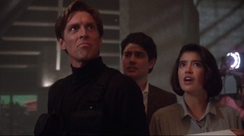 Movie still from “Gremlins 2: The New Batch” (1990), directed by Joe Dante – A group of people standing next to each other in a room; Medium shot, Low angle