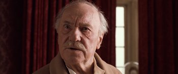 Movie still from “Greystoke: The Legend of Tarzan, Lord of the Apes” (1984), directed by Hugh Hudson – An old man with a mustache and a beard looking at the camera; Close Up shot, Low angle