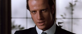Movie still from “Greystoke: The Legend of Tarzan, Lord of the Apes” (1984), directed by Hugh Hudson – A man in a black suit and a white tie; Close Up shot, Low angle