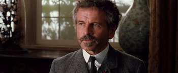 Movie still from “Greystoke: The Legend of Tarzan, Lord of the Apes” (1984), directed by Hugh Hudson – A person wearing a suit and tie; Close Up shot, Low angle