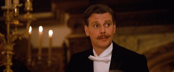 Movie still from “Greystoke: The Legend of Tarzan, Lord of the Apes” (1984), directed by Hugh Hudson – A man in a suit and a bow tie; Close Up shot, Low angle