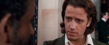 Movie still from “Greystoke: The Legend of Tarzan, Lord of the Apes” (1984), directed by Hugh Hudson – A person wearing a suit and tie; Close Up shot, Over the shoulder angle