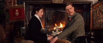 Movie still from “Greystoke: The Legend of Tarzan, Lord of the Apes” (1984), directed by Hugh Hudson – A man and a woman sitting in front of a fireplace; Medium shot, Over the shoulder angle