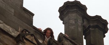 Movie still from “Greystoke: The Legend of Tarzan, Lord of the Apes” (1984), directed by Hugh Hudson – A man standing on top of a stone building; Medium shot, Low angle