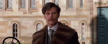 Movie still from “Greystoke: The Legend of Tarzan, Lord of the Apes” (1984), directed by Hugh Hudson – A person wearing a suit and tie; Close Up shot, Low angle