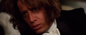 Movie still from “Greystoke: The Legend of Tarzan, Lord of the Apes” (1984), directed by Hugh Hudson – A person wearing a suit and bow tie; Close Up shot, Low angle