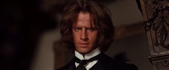 Movie still from “Greystoke: The Legend of Tarzan, Lord of the Apes” (1984), directed by Hugh Hudson – A person wearing a suit and tie; Close Up shot, Low angle