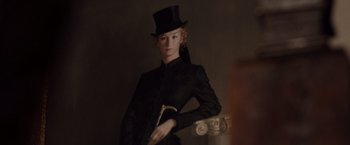 Movie still from “Greystoke: The Legend of Tarzan, Lord of the Apes” (1984), directed by Hugh Hudson – A painting of a woman in a top hat holding a cane; Medium shot, Low angle