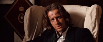 Movie still from “Greystoke: The Legend of Tarzan, Lord of the Apes” (1984), directed by Hugh Hudson – A person wearing a suit and tie; Close Up shot, Low angle