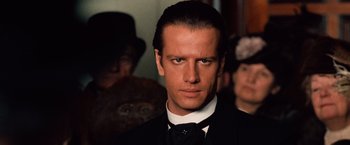 Movie still from “Greystoke: The Legend of Tarzan, Lord of the Apes” (1984), directed by Hugh Hudson – A person wearing a suit and a bow tie; Close Up shot, Low angle