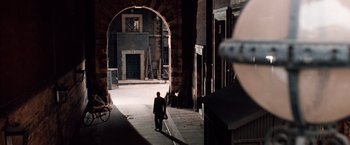 Movie still from “Greystoke: The Legend of Tarzan, Lord of the Apes” (1984), directed by Hugh Hudson – A man walking down a street in a tunnel; Wide shot, High angle