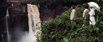 Movie still from “Greystoke: The Legend of Tarzan, Lord of the Apes” (1984), directed by Hugh Hudson – A man standing on top of a tree near a waterfall; Extreme Wide shot, High angle