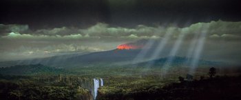 Movie still from “Greystoke: The Legend of Tarzan, Lord of the Apes” (1984), directed by Hugh Hudson – A view of a mountain with a fire in the background; Extreme Wide shot, High angle