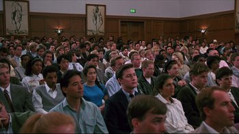 Movie still from “Gross Anatomy” (1989), directed by Thom Eberhardt – A crowd of people sitting in a large room; Wide shot, High angle