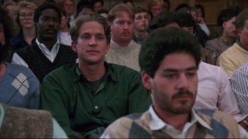 Movie still from “Gross Anatomy” (1989), directed by Thom Eberhardt – A group of people sitting in a room watching something; Close Up shot, High angle
