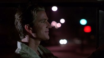 Movie still from “Gross Anatomy” (1989), directed by Thom Eberhardt – A person sitting in a car at night; Close Up shot, Over the shoulder angle