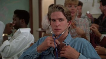 Movie still from “Gross Anatomy” (1989), directed by Thom Eberhardt – A man with a stethoscope around his neck; Close Up shot, Low angle