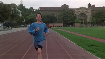 Movie still from “Gross Anatomy” (1989), directed by Thom Eberhardt – A young man running on a track on a field; Wide shot, Low angle