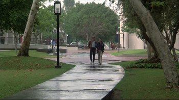 Movie still from “Gross Anatomy” (1989), directed by Thom Eberhardt – Two men walking down a sidewalk near a park; Wide shot, High angle