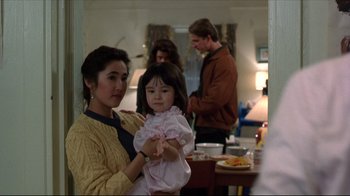 Movie still from “Gross Anatomy” (1989), directed by Thom Eberhardt – A woman holding a little girl in her arms; Medium shot, Over the shoulder angle