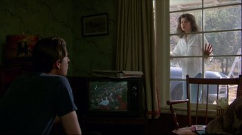 Movie still from “Gross Anatomy” (1989), directed by Thom Eberhardt – A man and a woman are watching television; Medium shot, Over the shoulder angle