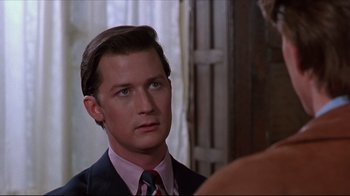 Movie still from “Gross Anatomy” (1989), directed by Thom Eberhardt – A man wearing a suit and tie looking at a woman; Close Up shot, Over the shoulder angle