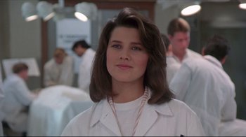 Movie still from “Gross Anatomy” (1989), directed by Thom Eberhardt – A woman in a white lab coat standing in front of a group of people; Close Up shot, Low angle