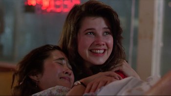 Movie still from “Gross Anatomy” (1989), directed by Thom Eberhardt – Two young girls are hugging and smiling for the camera; Close Up shot, Low angle