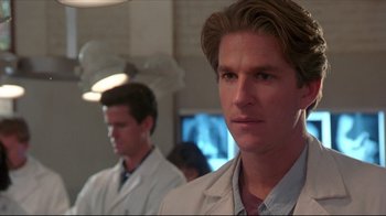 Movie still from “Gross Anatomy” (1989), directed by Thom Eberhardt – A man in a lab coat standing next to another man in a lab coat; Close Up shot, Low angle