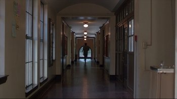 Movie still from “Gross Anatomy” (1989), directed by Thom Eberhardt – A person walking down a hall way in a building; Extreme Wide shot, Low angle