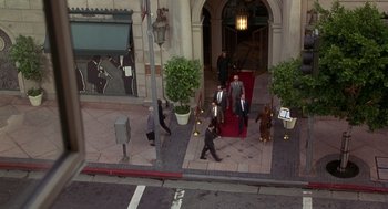 Movie still from “Grosse Pointe Blank” (1997), directed by George Armitage – A group of people walking down a sidewalk; Extreme Wide shot, High angle