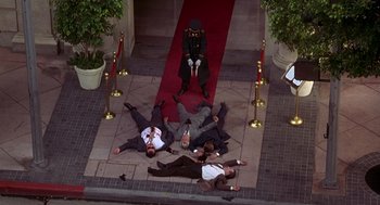 Movie still from “Grosse Pointe Blank” (1997), directed by George Armitage – A group of men laying on the ground next to each other; Wide shot, Overhead angle