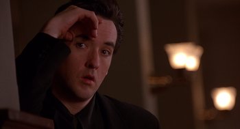 Movie still from “Grosse Pointe Blank” (1997), directed by George Armitage – A person wearing a suit and tie; Close Up shot, Over the shoulder angle