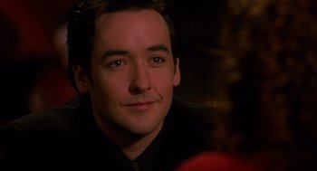 Movie still from “Grosse Pointe Blank” (1997), directed by George Armitage – A person wearing a suit and tie; Close Up shot, Over the shoulder angle