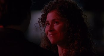 Movie still from “Grosse Pointe Blank” (1997), directed by George Armitage – A person with curly hair smiling; Close Up shot, Over the shoulder angle