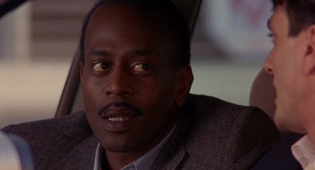 Movie still from “Grosse Pointe Blank” (1997), directed by George Armitage – A person wearing a suit and tie; Close Up shot, Low angle