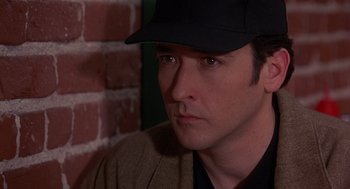 Movie still from “Grosse Pointe Blank” (1997), directed by George Armitage – A person wearing a hat; Close Up shot, Over the shoulder angle