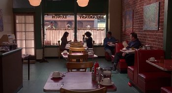 Movie still from “Grosse Pointe Blank” (1997), directed by George Armitage – People are sitting at tables in a restaurant; Wide shot, High angle