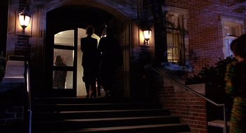Movie still from “Grosse Pointe Blank” (1997), directed by George Armitage – Two people are standing on the steps at night; Wide shot, Low angle