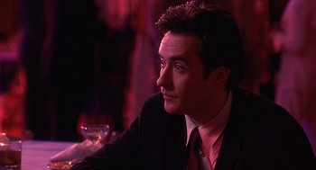 Movie still from “Grosse Pointe Blank” (1997), directed by George Armitage – A person wearing a suit and tie; Close Up shot, Over the shoulder angle