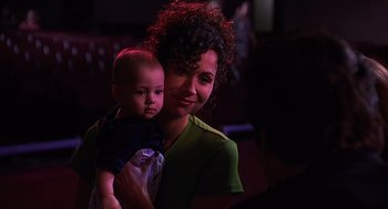 Movie still from “Grosse Pointe Blank” (1997), directed by George Armitage – A woman holding a baby in her arms; Close Up shot, Over the shoulder angle