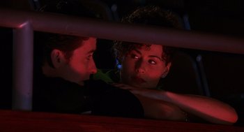 Movie still from “Grosse Pointe Blank” (1997), directed by George Armitage – A man and a woman looking at one another through a window; Close Up shot, High angle