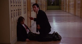 Movie still from “Grosse Pointe Blank” (1997), directed by George Armitage – A man in a suit and a man in a tie in front of lockers; Medium shot, High angle
