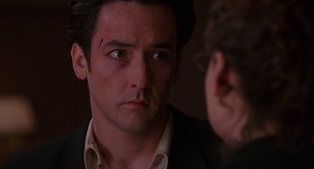 Movie still from “Grosse Pointe Blank” (1997), directed by George Armitage – A person looking at a mirror; Close Up shot, Over the shoulder angle
