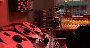 Movie still from “Grosse Pointe Blank” (1997), directed by George Armitage – A room that has a lot of tapes on it; Extreme Close Up shot, High angle