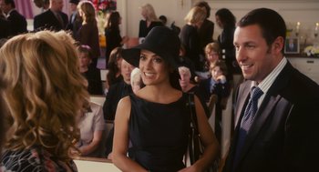 Movie still from “Grown Ups” (2010), directed by Dennis Dugan – A woman in a black dress wearing a black hat; Medium shot, Over the shoulder angle