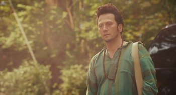 Movie still from “Grown Ups” (2010), directed by Dennis Dugan – A man in a green shirt is standing in front of a tree; Close Up shot, Over the shoulder angle