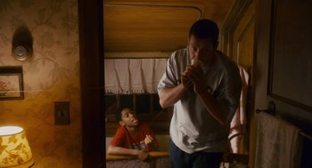 Movie still from “Grown Ups” (2010), directed by Dennis Dugan – A man standing next to another man in a room; Medium shot, Low angle