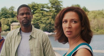 Movie still from “Grown Ups” (2010), directed by Dennis Dugan – A man and a woman standing next to each other near a body of water; Medium shot, Over the shoulder angle